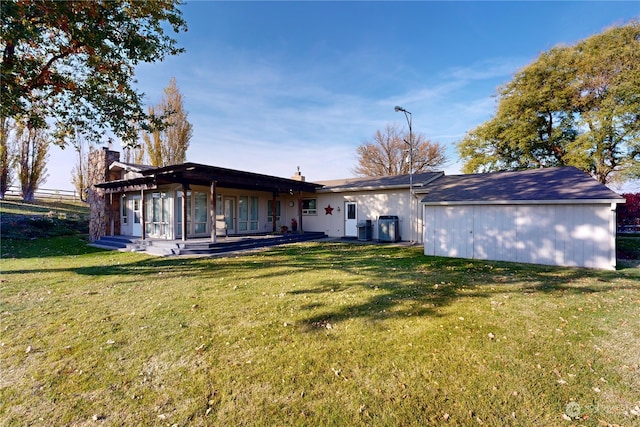 rear view of property with a sunroom and a yard