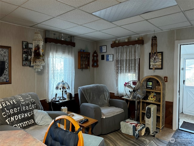 living room with tile patterned floors and a drop ceiling