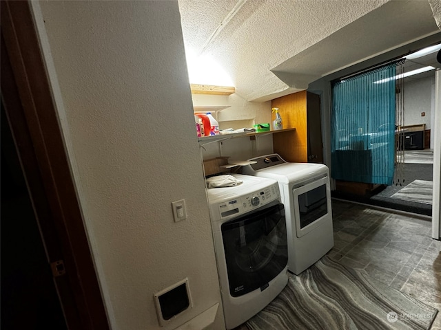 laundry room with independent washer and dryer and a textured ceiling