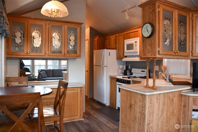 kitchen with decorative light fixtures, white appliances, dark hardwood / wood-style flooring, sink, and kitchen peninsula