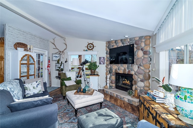 living room with lofted ceiling, hardwood / wood-style flooring, and a fireplace