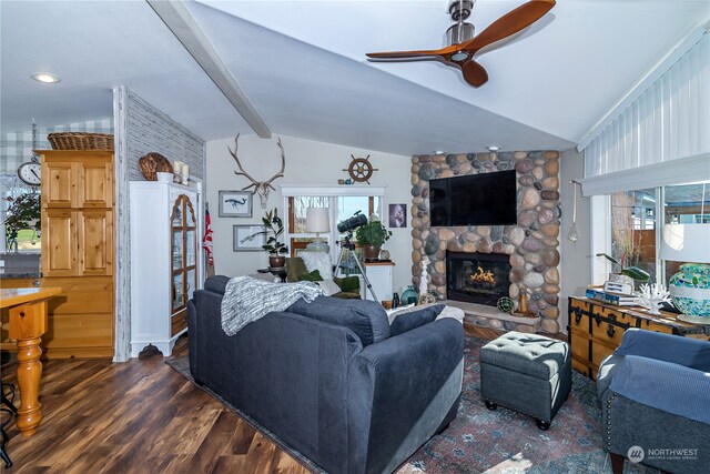 living room with a stone fireplace, lofted ceiling with beams, dark hardwood / wood-style flooring, and ceiling fan