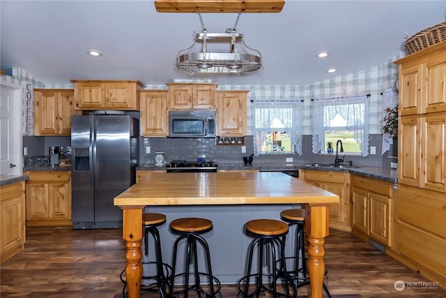 kitchen with butcher block countertops, appliances with stainless steel finishes, sink, and dark hardwood / wood-style floors