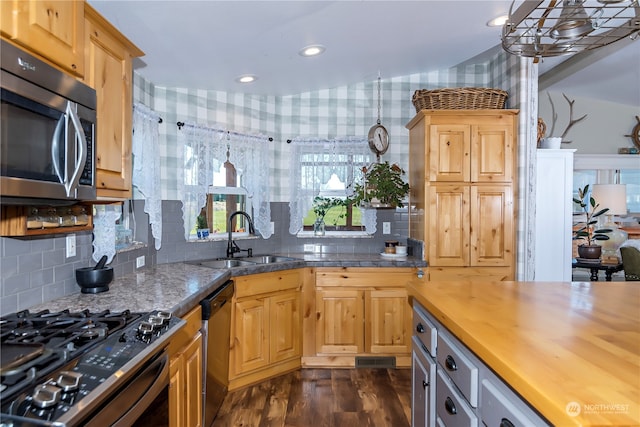 kitchen with stainless steel appliances, dark wood-type flooring, sink, butcher block countertops, and pendant lighting