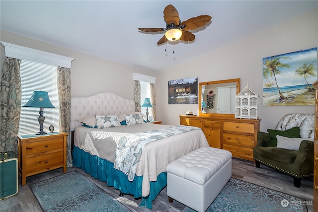 bedroom with multiple windows, wood-type flooring, lofted ceiling, and ceiling fan