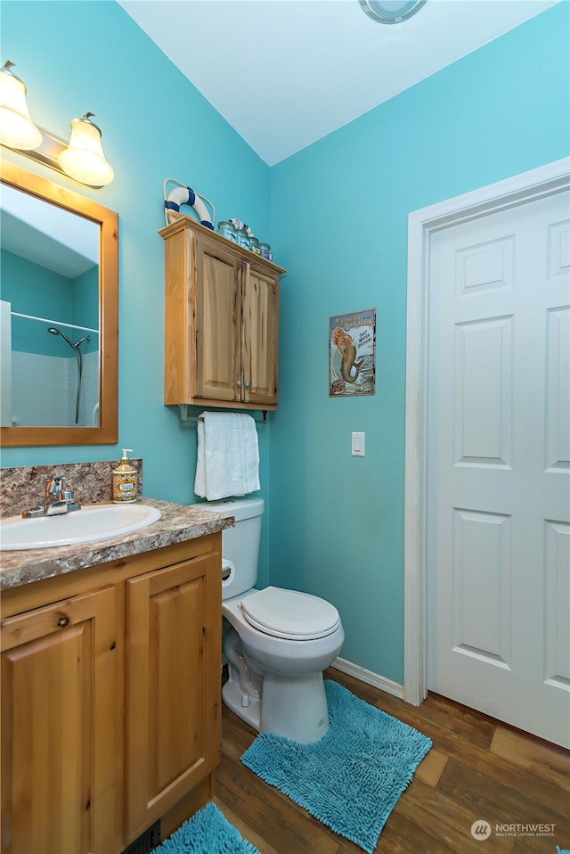 bathroom with walk in shower, wood-type flooring, toilet, and vanity