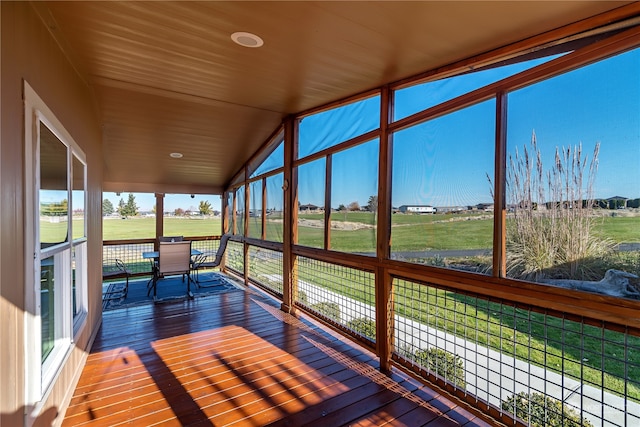 unfurnished sunroom with wooden ceiling, a rural view, and lofted ceiling