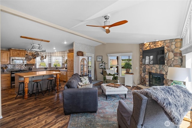 205 Fairway Pl SW, Mattawa, WA 99349 - living room featuring healthy amount of natural light, dark wood-style flooring, a stone fireplace, and a ceiling fan