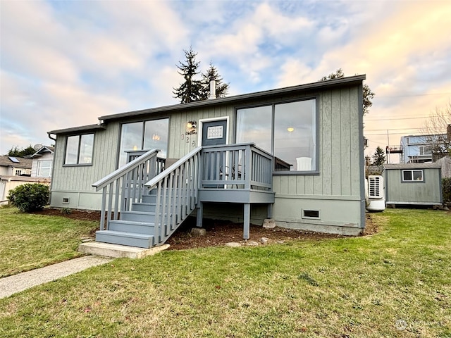 manufactured / mobile home featuring a lawn and a storage unit