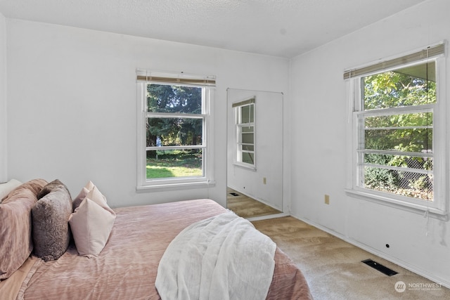 carpeted bedroom featuring a textured ceiling