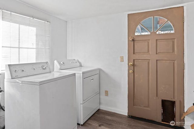 laundry room with dark wood-type flooring, a healthy amount of sunlight, and washer and dryer