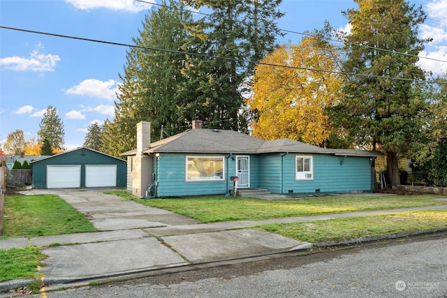 ranch-style home featuring a garage, a front lawn, and an outbuilding