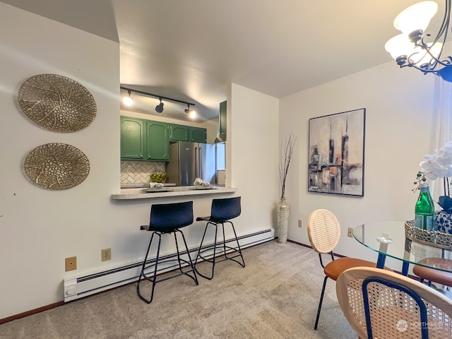 carpeted dining room with a baseboard radiator, rail lighting, and a notable chandelier