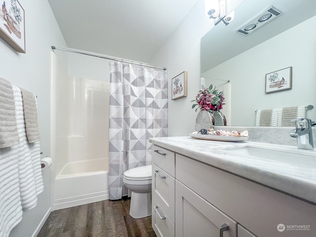 full bathroom with hardwood / wood-style floors, shower / tub combo with curtain, vanity, toilet, and tile walls