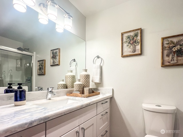 bathroom featuring toilet, an enclosed shower, and vanity