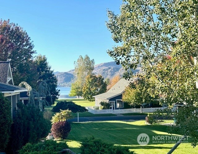 view of home's community with a mountain view and a yard