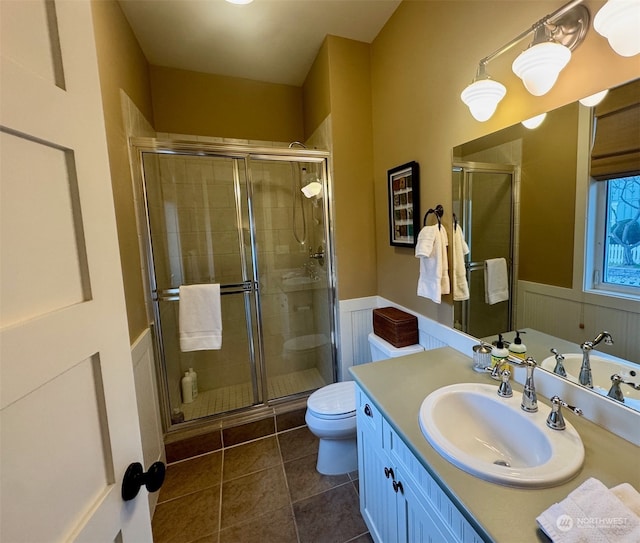 bathroom featuring walk in shower, vanity, toilet, and tile patterned flooring