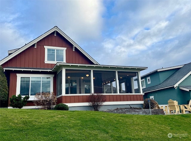 back of house featuring a yard and a sunroom