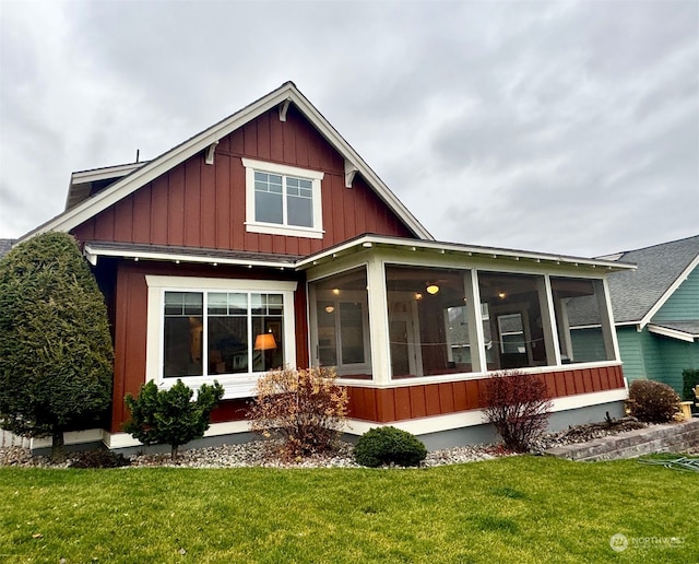 rear view of property with a yard and a sunroom