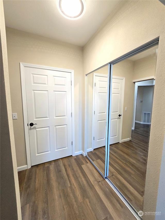 unfurnished bedroom featuring dark hardwood / wood-style flooring and a closet