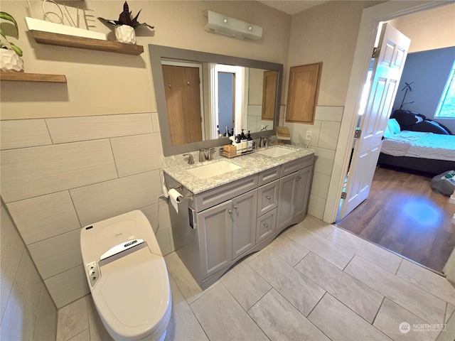 bathroom featuring tile patterned flooring, a wall mounted AC, toilet, vanity, and tile walls