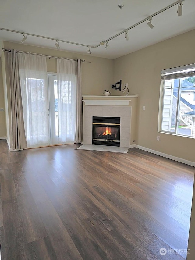 unfurnished living room with a wealth of natural light, a fireplace, and hardwood / wood-style floors