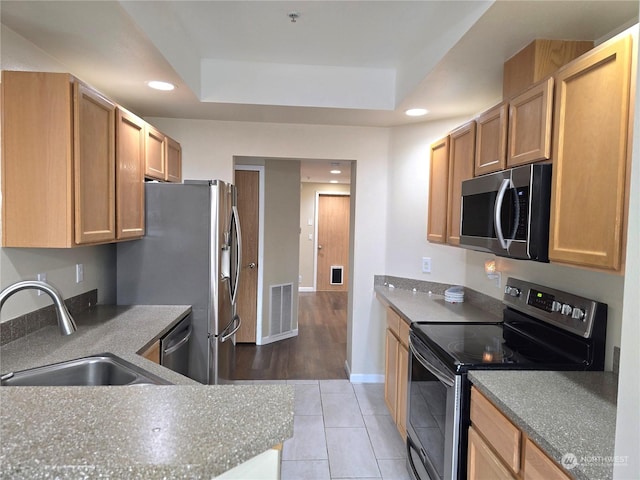 kitchen featuring light tile patterned floors, stainless steel appliances, a raised ceiling, and sink