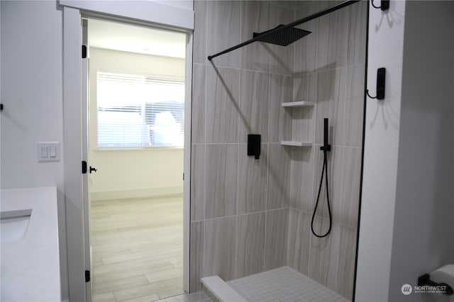 bathroom featuring hardwood / wood-style floors and a tile shower