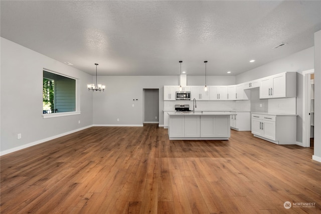 kitchen with white cabinetry, stainless steel appliances, and light hardwood / wood-style floors