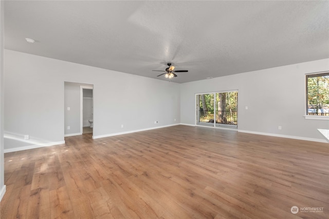 spare room with light wood-type flooring, plenty of natural light, and ceiling fan