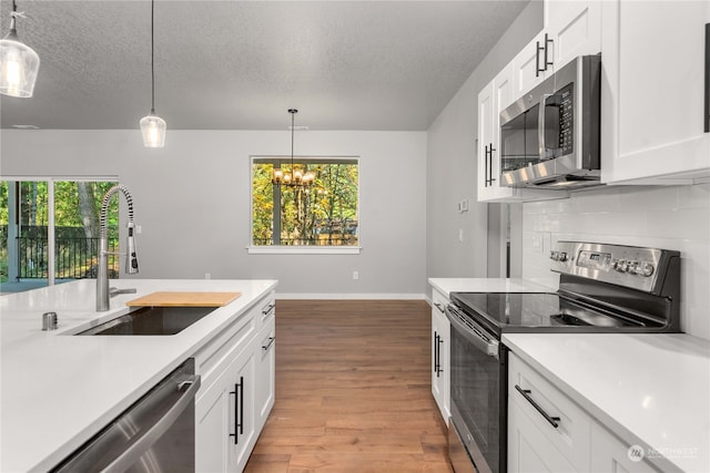 kitchen featuring stainless steel appliances, a healthy amount of sunlight, sink, and white cabinets