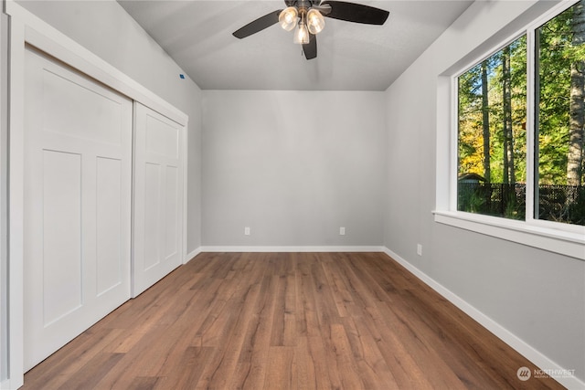 unfurnished bedroom with hardwood / wood-style flooring, ceiling fan, and a closet