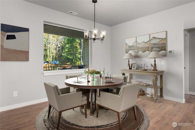 dining room featuring hardwood / wood-style floors and an inviting chandelier