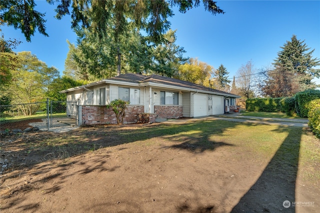 ranch-style house featuring a garage and a front lawn