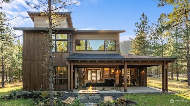 rear view of property featuring a patio area and a fire pit