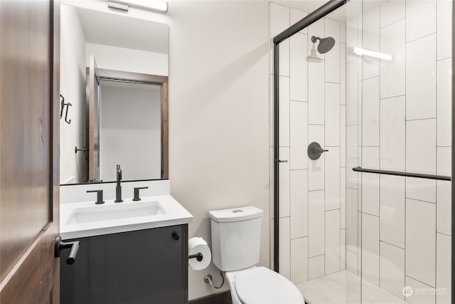 bathroom with vanity, a shower with shower door, and toilet