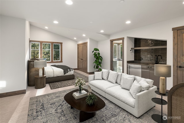 carpeted living room featuring sink and vaulted ceiling