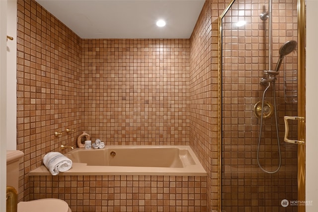 bathroom featuring tile walls, toilet, and shower with separate bathtub