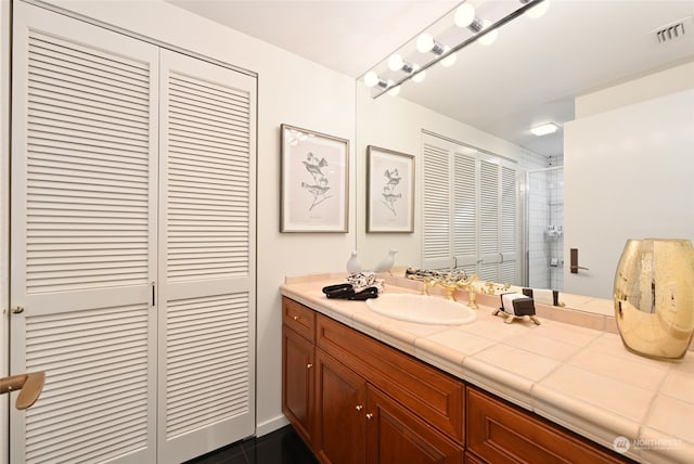 bathroom with vanity and tiled shower