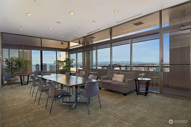 carpeted dining area featuring a wall of windows