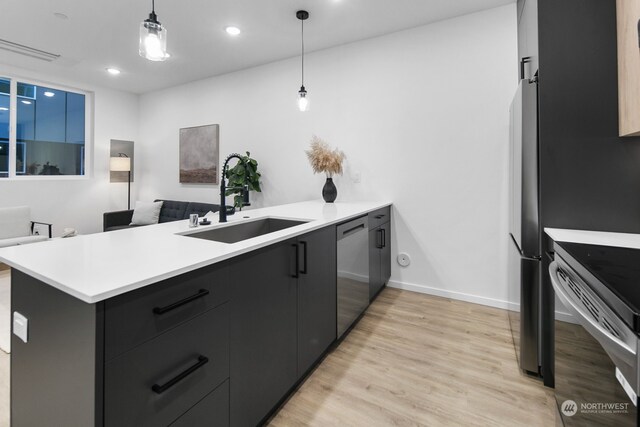 kitchen with pendant lighting, kitchen peninsula, sink, and appliances with stainless steel finishes