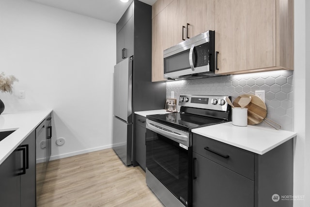 kitchen featuring backsplash, light hardwood / wood-style floors, stainless steel appliances, and light brown cabinets