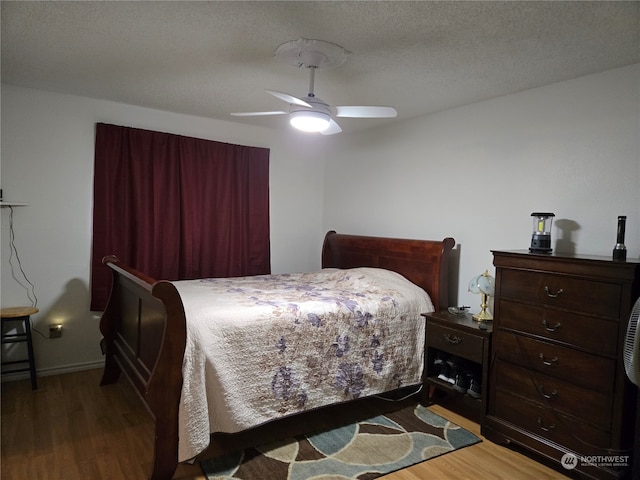 bedroom featuring hardwood / wood-style flooring, ceiling fan, and a textured ceiling