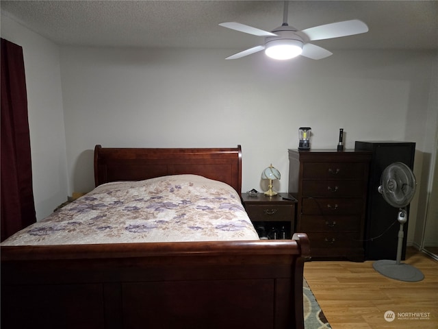 bedroom featuring a textured ceiling, light hardwood / wood-style flooring, and ceiling fan