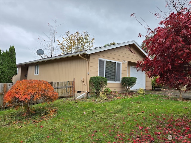 view of home's exterior featuring a lawn and a garage