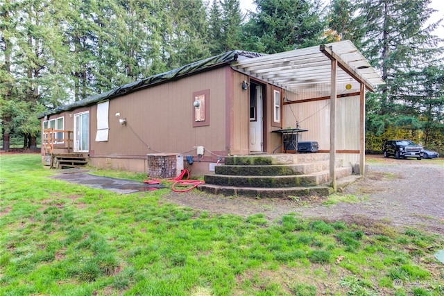 view of side of home featuring central AC unit and a lawn