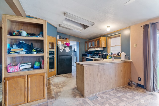 kitchen featuring sink, kitchen peninsula, appliances with stainless steel finishes, a textured ceiling, and vaulted ceiling