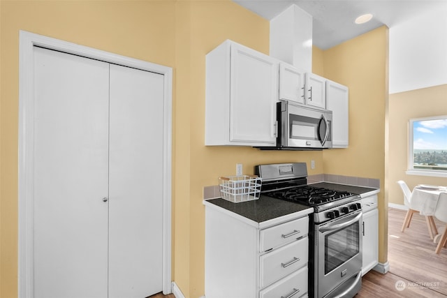 404 E 31st St, Bremerton, WA 98310 - kitchen with light hardwood / wood-style flooring, appliances with stainless steel finishes, and white cabinets