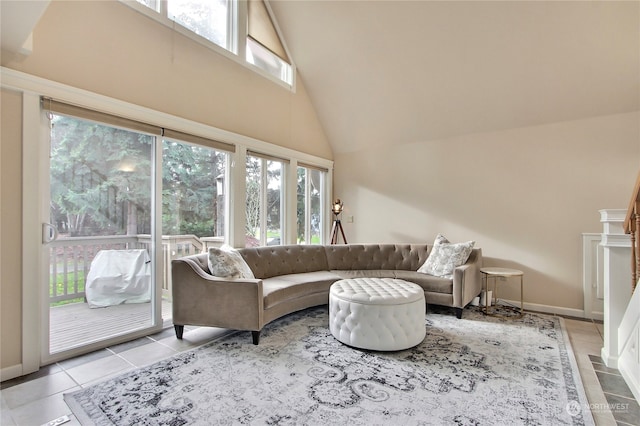 tiled living room with plenty of natural light and high vaulted ceiling