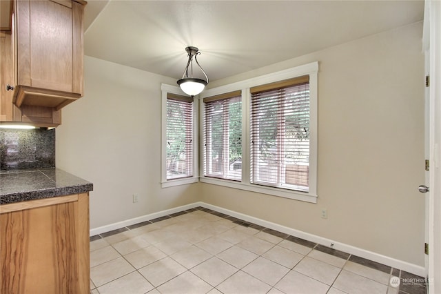 unfurnished dining area featuring a wealth of natural light and light tile patterned floors